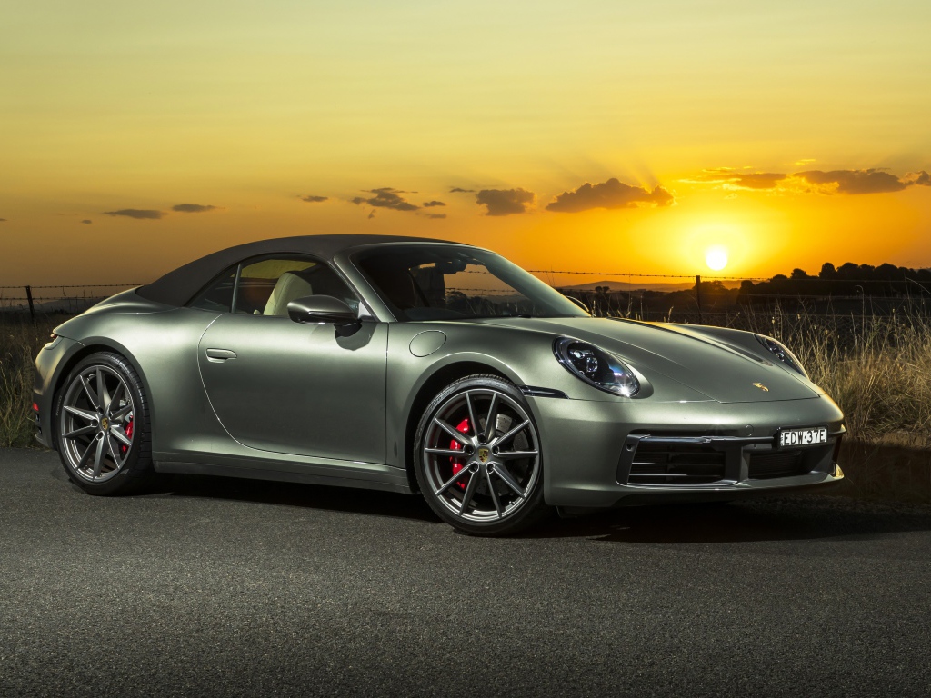 Серебристый Porsche 911 Carrera S Cabriolet 2020 года на закате 