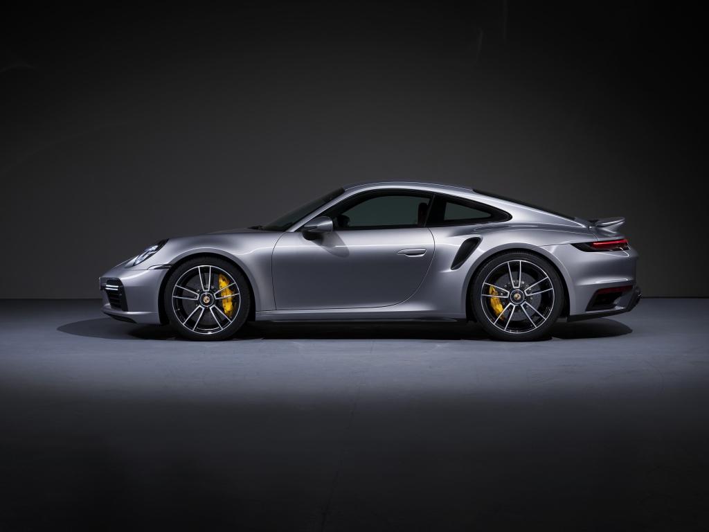Серебристый автомобиль Porsche 911 Turbo S 2020 года вид сбоку 