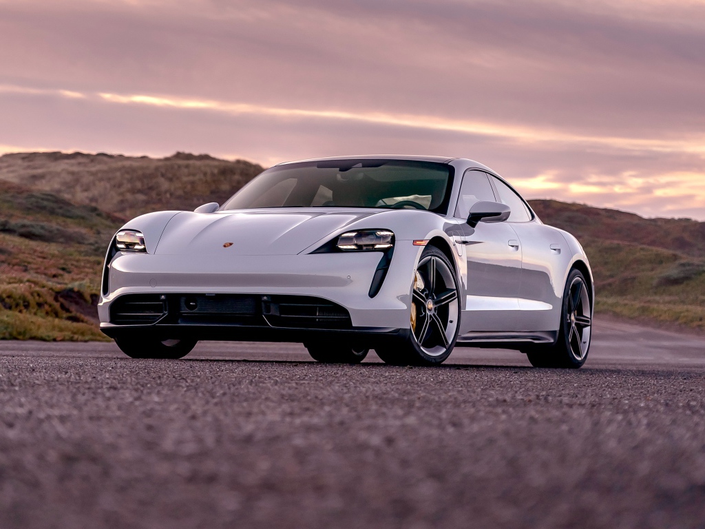 Серебристый автомобиль Porsche Taycan Turbo S 2020 года на фоне неба