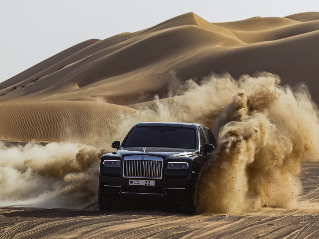 Черный автомобиль Rolls-Royce Cullinan в пустыне