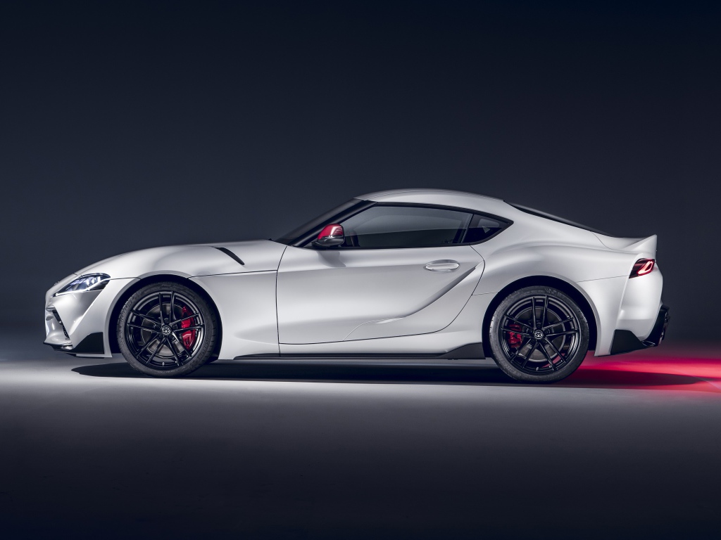 Серый автомобиль Toyota GR Supra 2L 2020 года вид сбоку на сером фоне