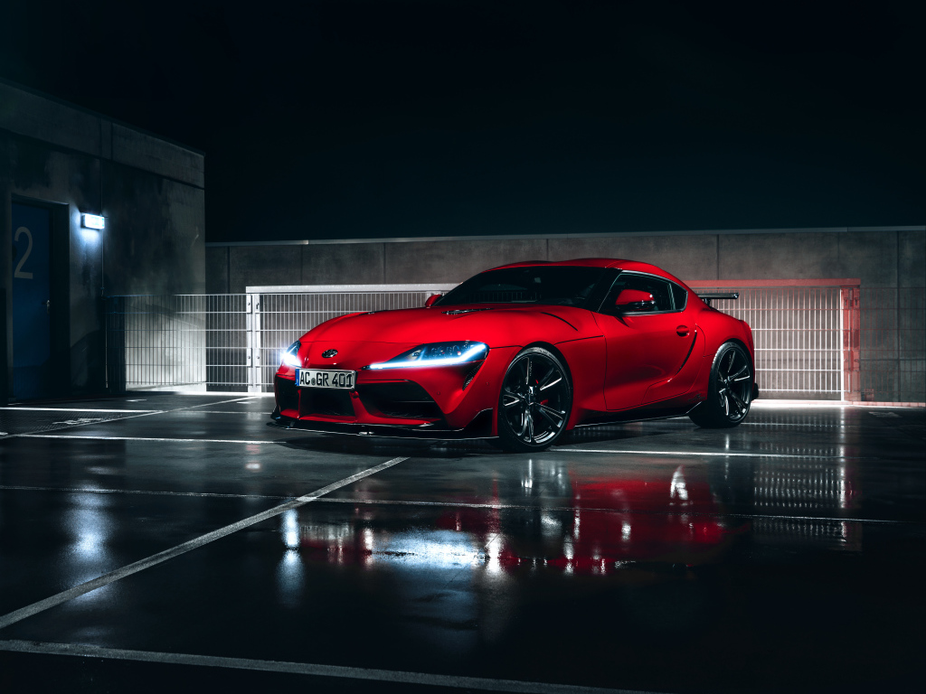 Красный автомобиль Toyota GR Supra AC Schnitzer 2019 года у гаража