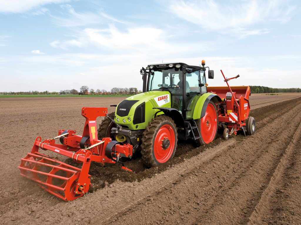 Большой комбайн сеет в поле 