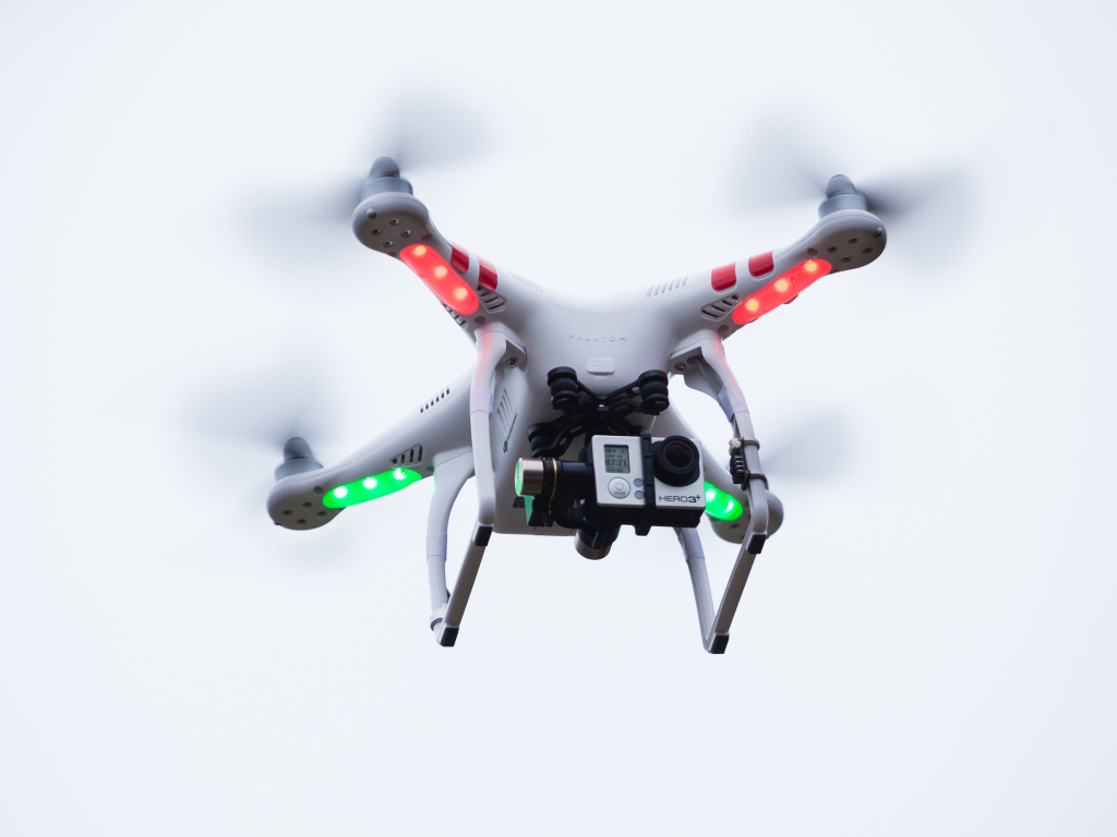 Квадрокоптер с видеокамерой на белом фоне