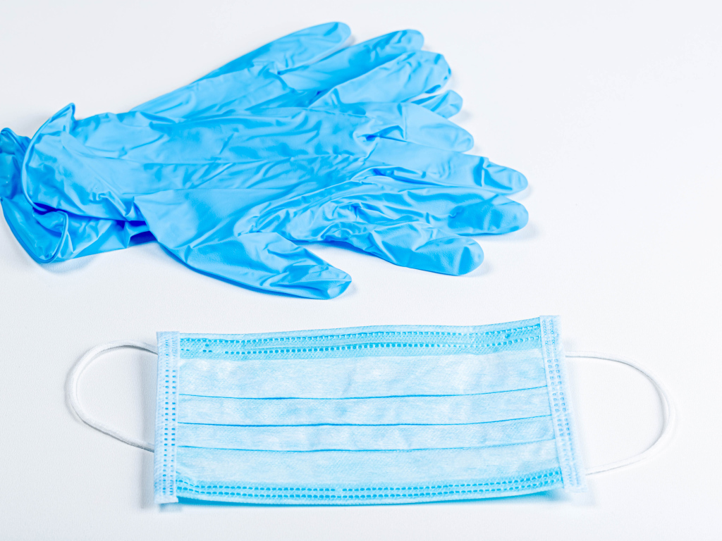 Синие перчатки и маска для лица на белом фоне от коронавируса 