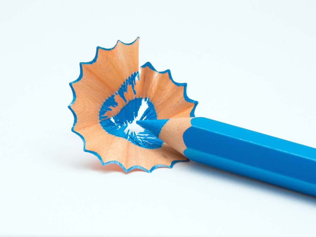 Голубой карандаш со стружкой на белом фоне