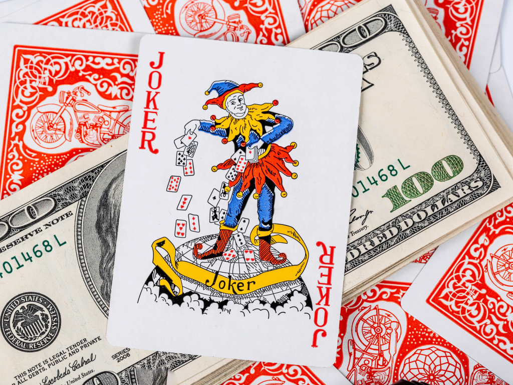 Card Joker and a pack of hundred-dollar bills