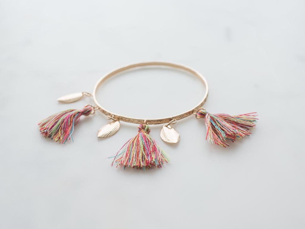 Золотой браслет на сером фоне