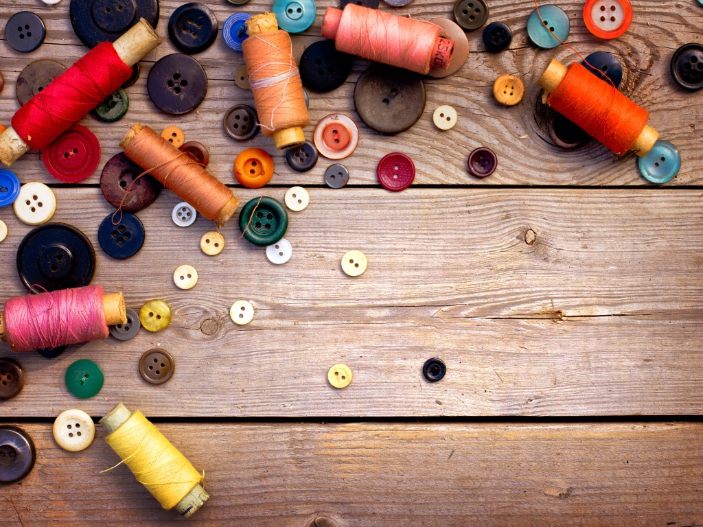 Разноцветные пуговицы и нитки лежат на столе