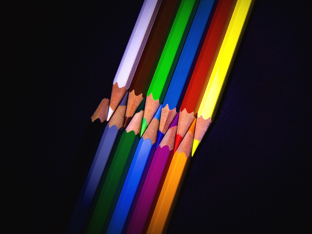 Разноцветные острые карандаши на черном фоне