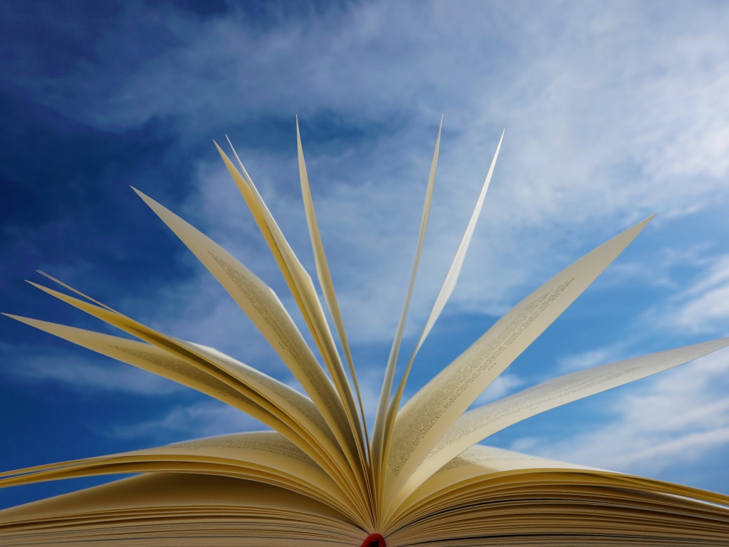 Открытые страницы книги на фоне голубого неба