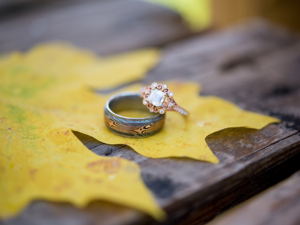 Золотые кольца с желтым листом на столе 