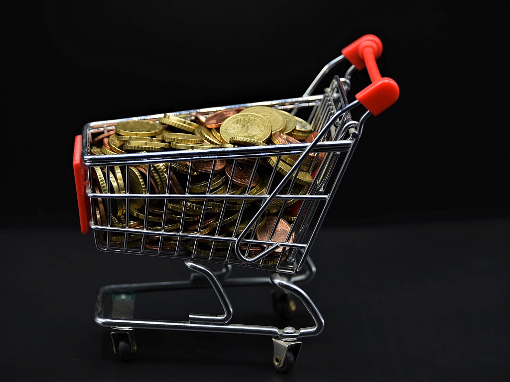 Железная тележка с монетами на черном фоне 