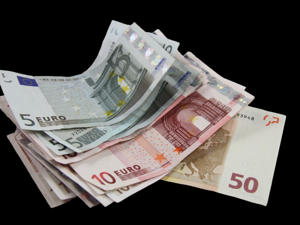 Много бумажных купюр евро на черном фоне