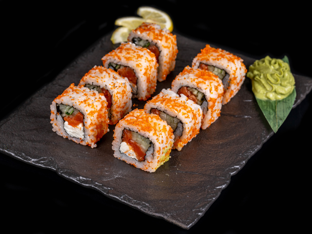 Аппетитные японские роллы с соусом васаби на черном фоне