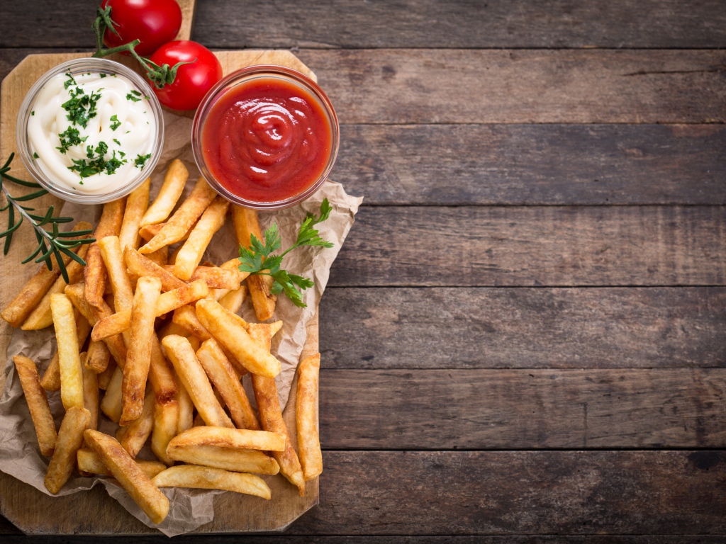 Аппетитный картофель фри на столе с соусом и кетчупом 