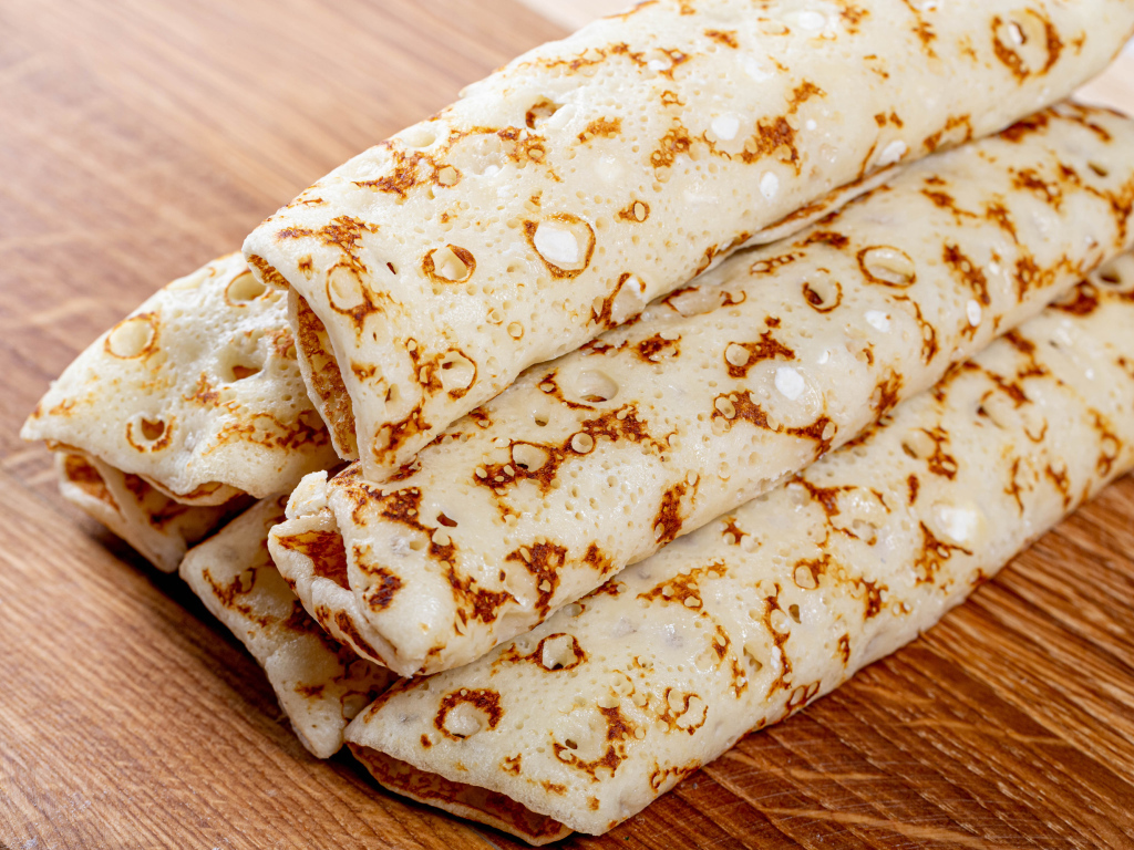 Аппетитные блины на деревянном столе 