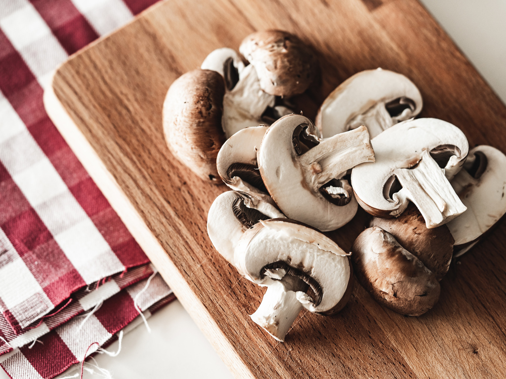 Нарезанные шампиньоны на разделочной доске