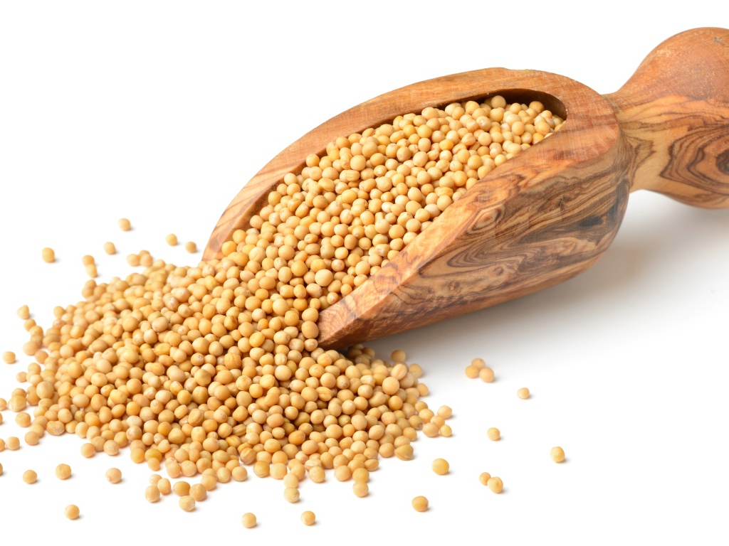 Мелкий горох в деревянном совке на белом фоне