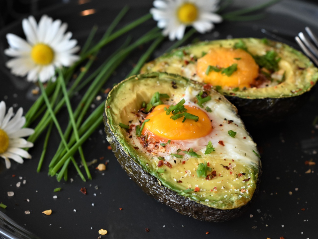 Baked avocado with scrambled eggs in a pan