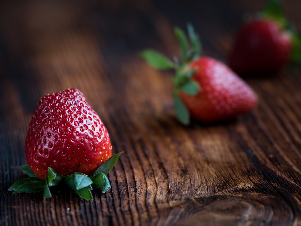 Большая крупная красная клубника на деревянном столе