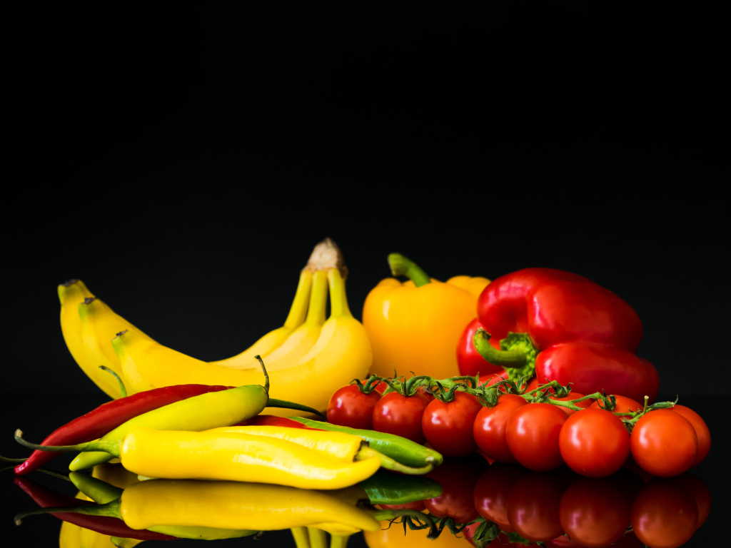 Перец, помидоры и бананы на черном фоне
