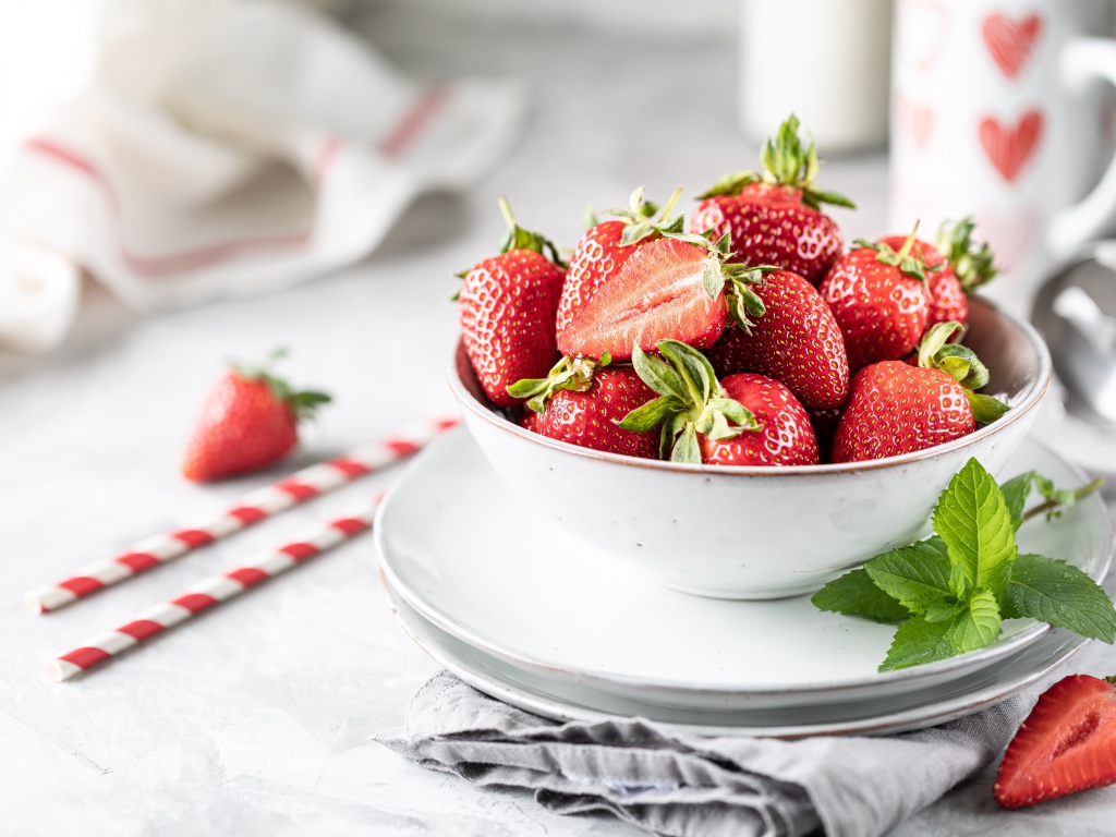 Спелая клубника в тарелке с листьями мяты