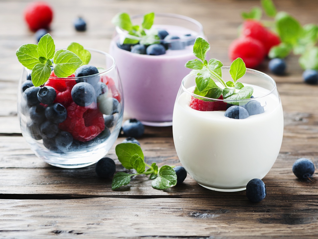 Вкусный йогурт с ягодами черники и малины на столе 