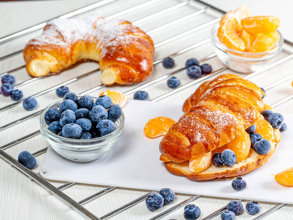 Свежие круассаны с ягодами черники и дольками мандарина 