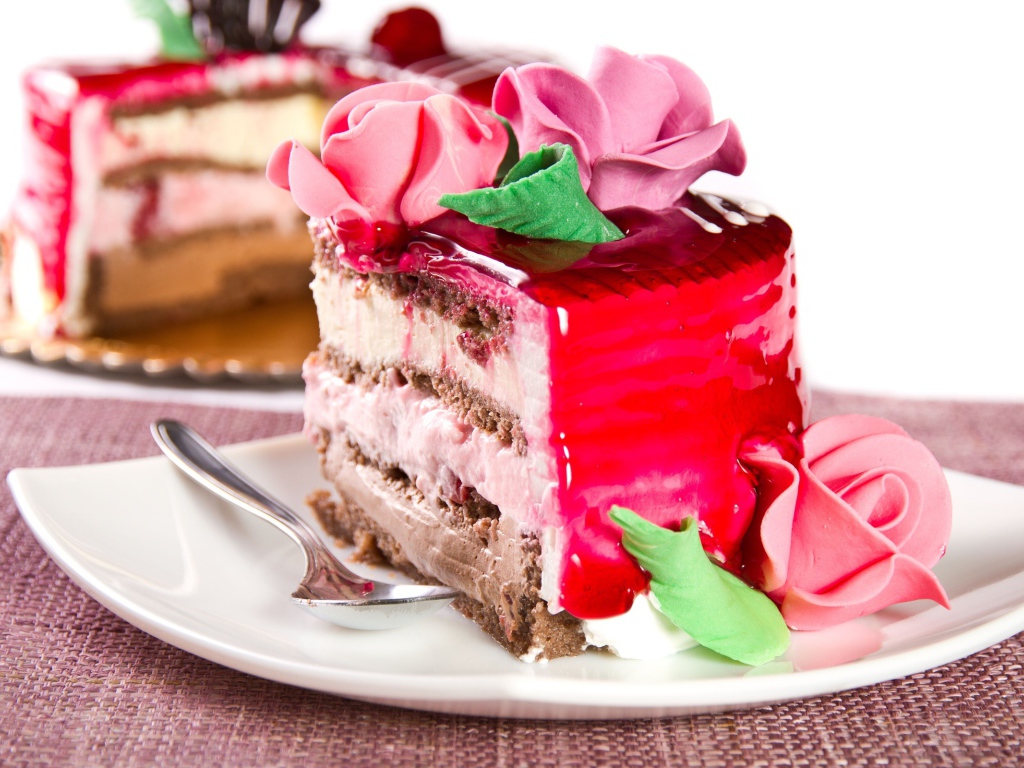 Кусок аппетитного торта декорирован розами из крема