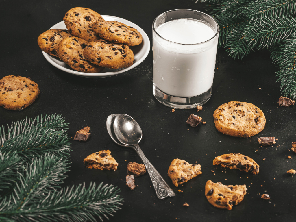 Печенье на столе с молоком и еловыми ветками