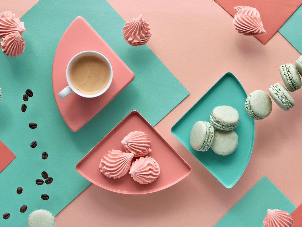 Чашка какао на столе с зефиром и десертом макарон 