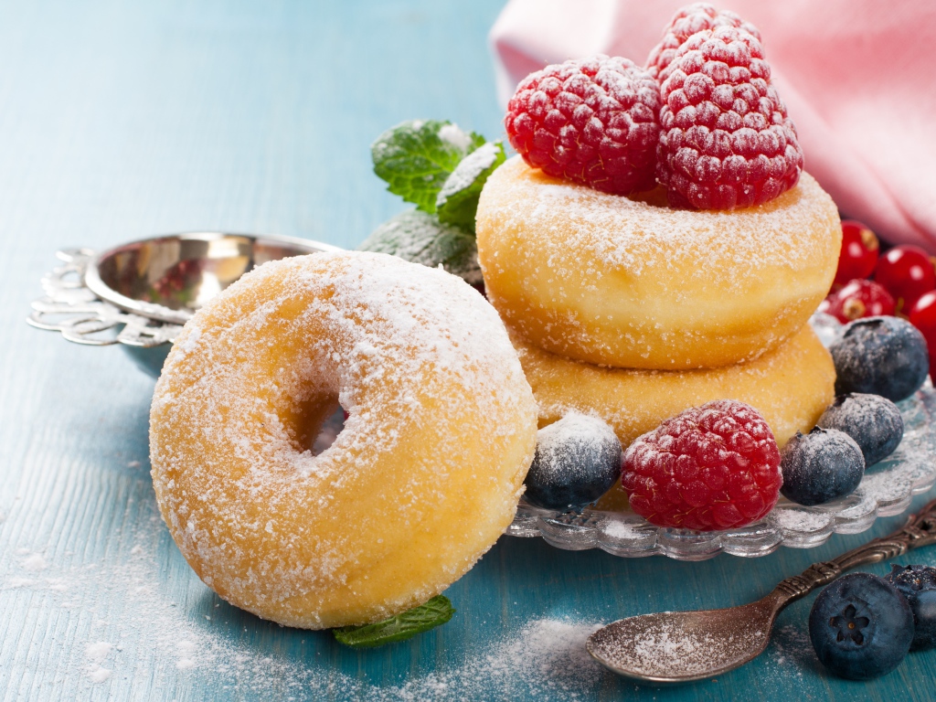 Вкусные пышные пончики с ягодами черники и малины с сахарной пудрой 