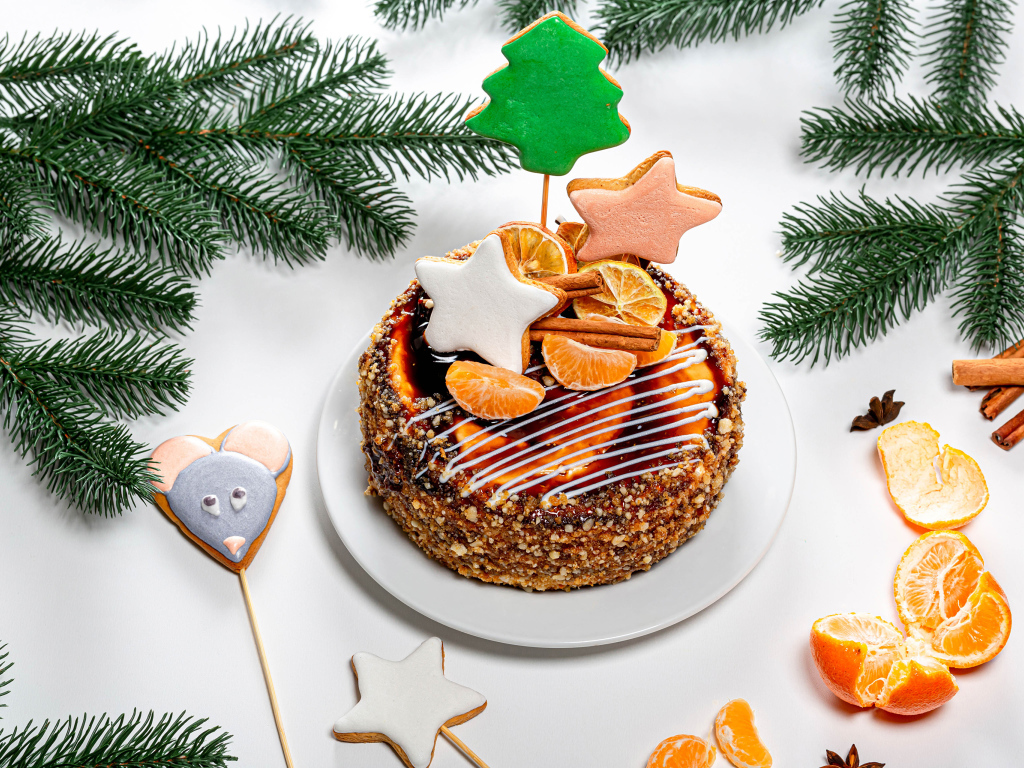 Праздничный торт на столе с мандаринами и еловыми ветками