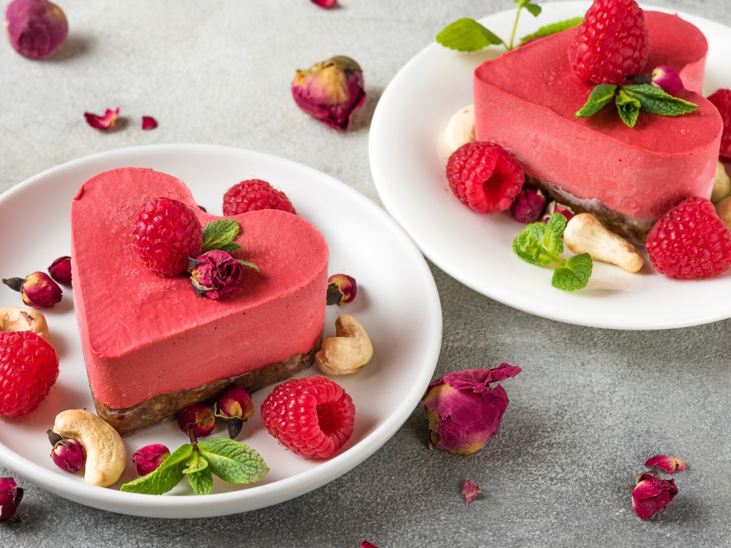 Фруктовое суфле в форме сердца на тарелке с малиной и орехами 