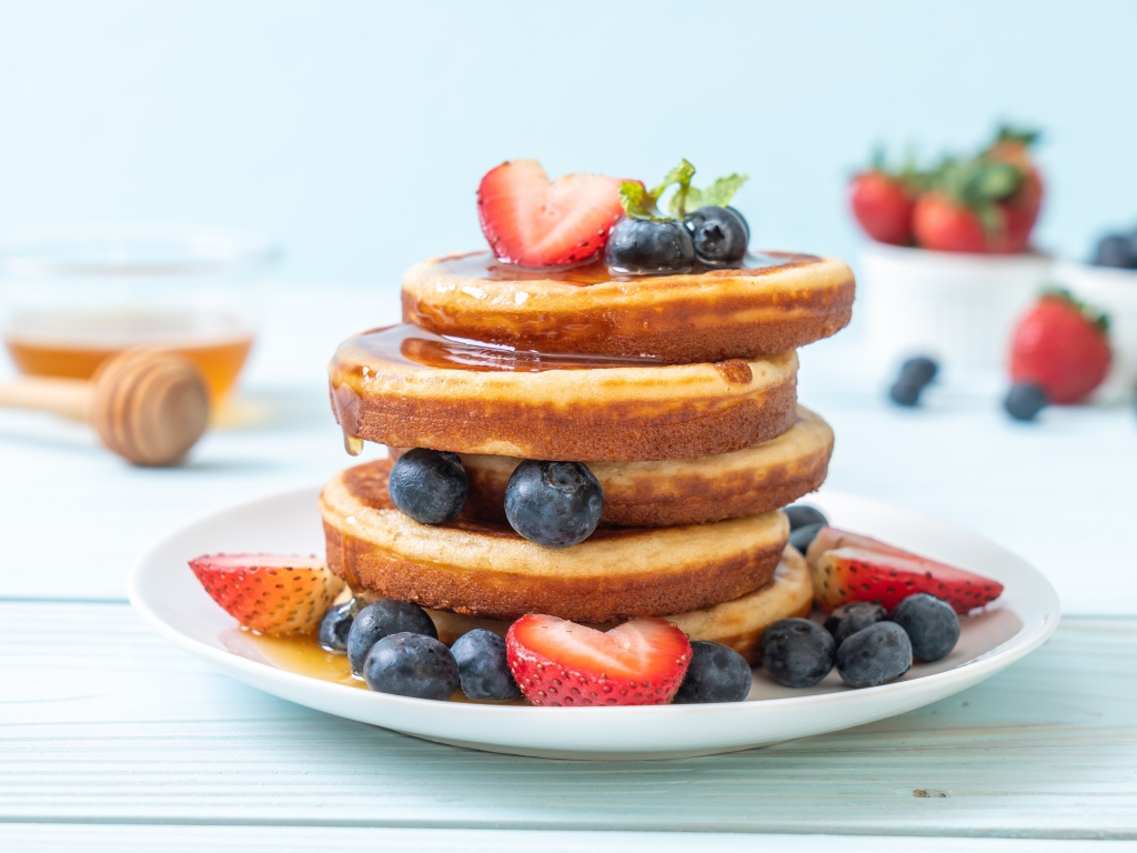 Пышные оладьи с ягодами черники, клубники и медом 