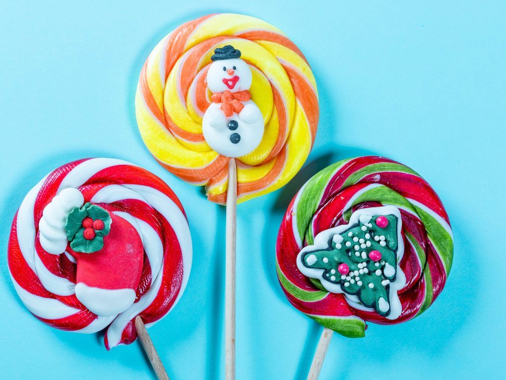 Разноцветные леденцы на палочках на голубом фоне
