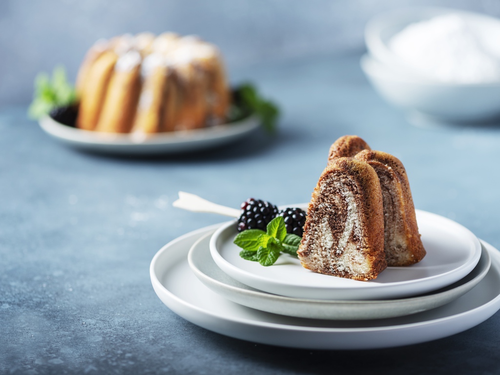 Кусочки кекса на тарелке с ягодами ежевики