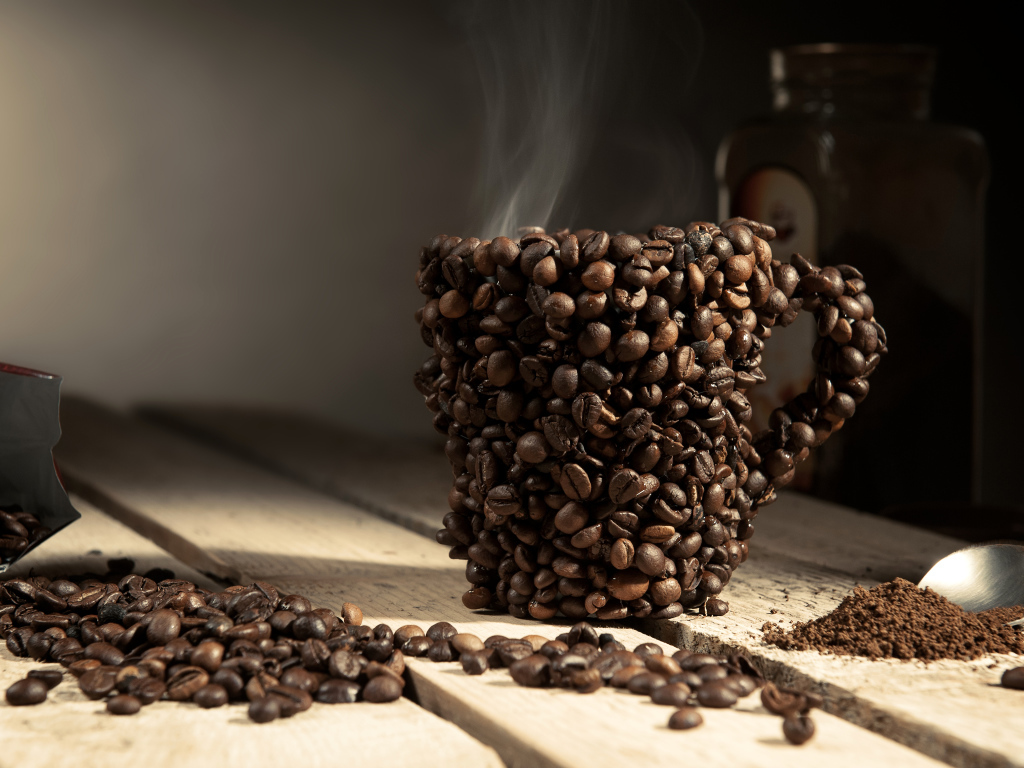 Чашка сделана из кофейных зерен на столе