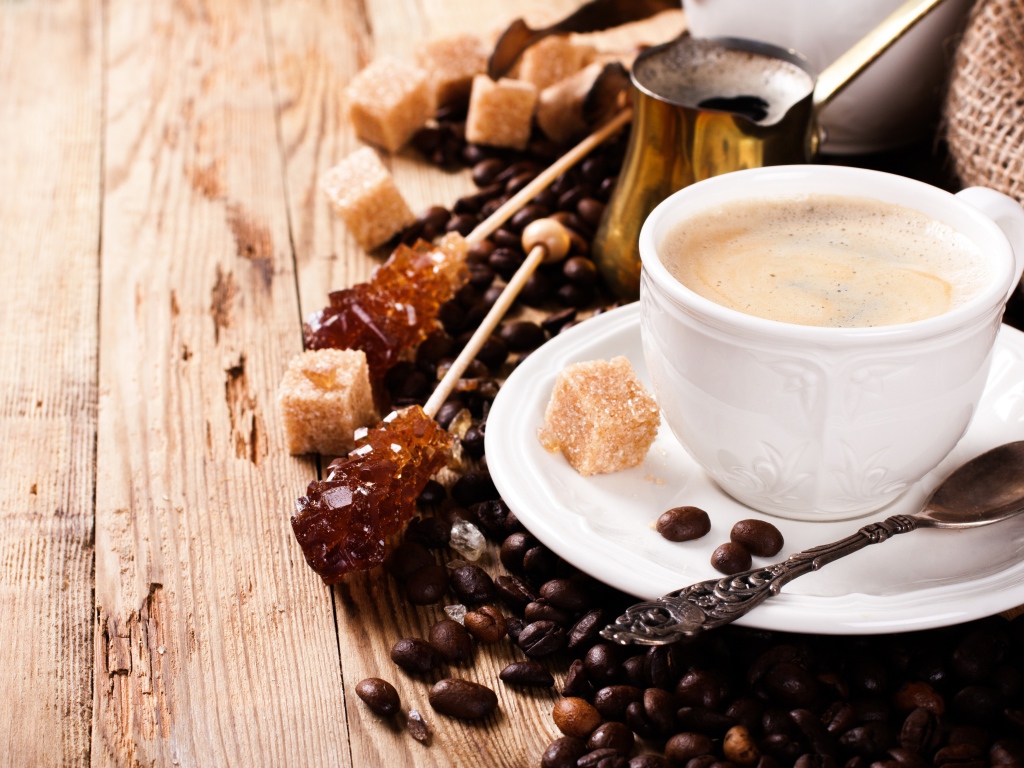 Чашка кофе на столе с леденцами и зернами