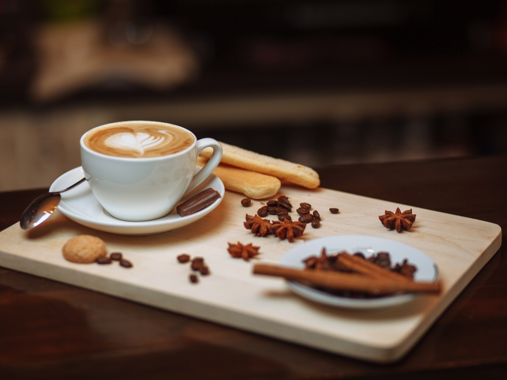 Чашка кофе на столе со специями и печеньем