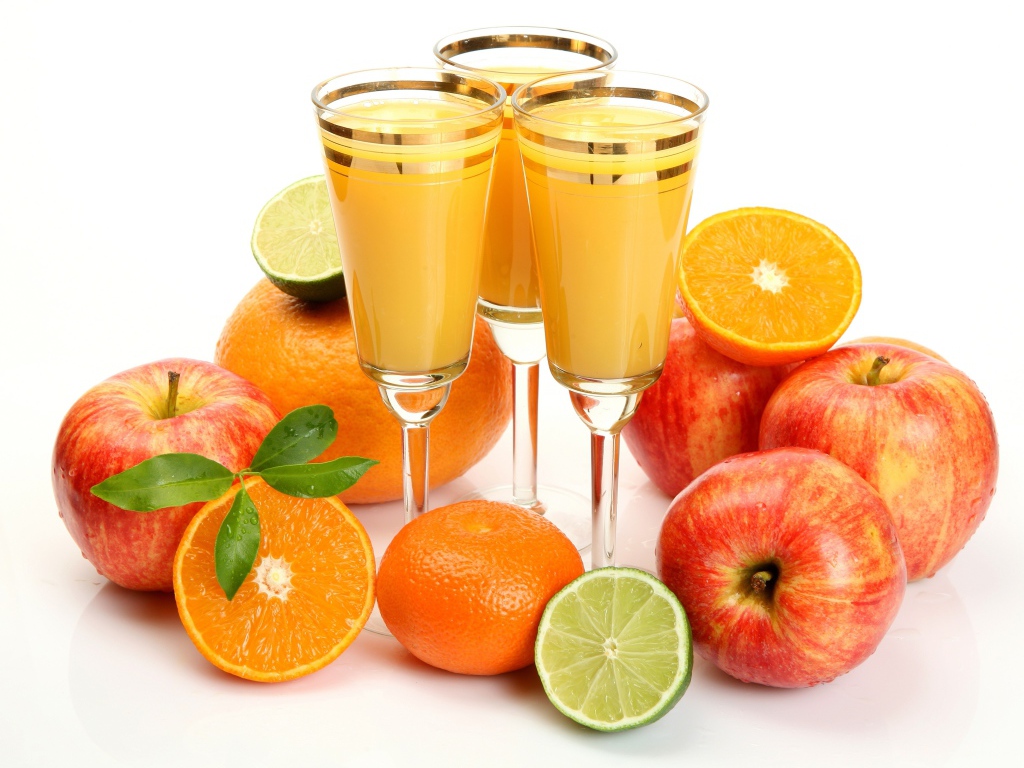 Свежий цитрусовый сок на белом фоне с яблоками, апельсинами  и лимоном
