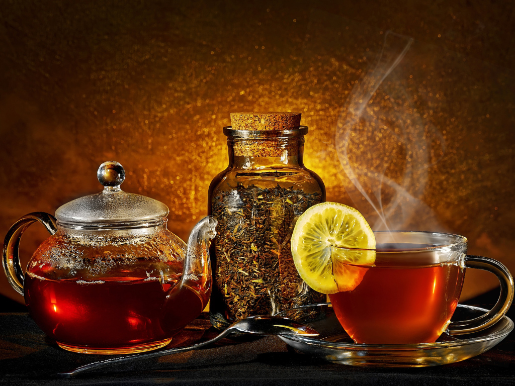 Стеклянный чайник с чашкой на столе с заваркой 