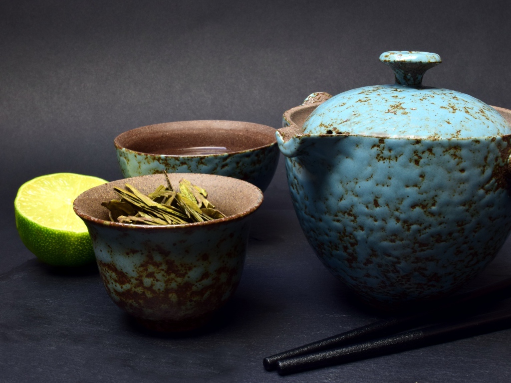 Зеленый чай на столе с посудой и лаймом