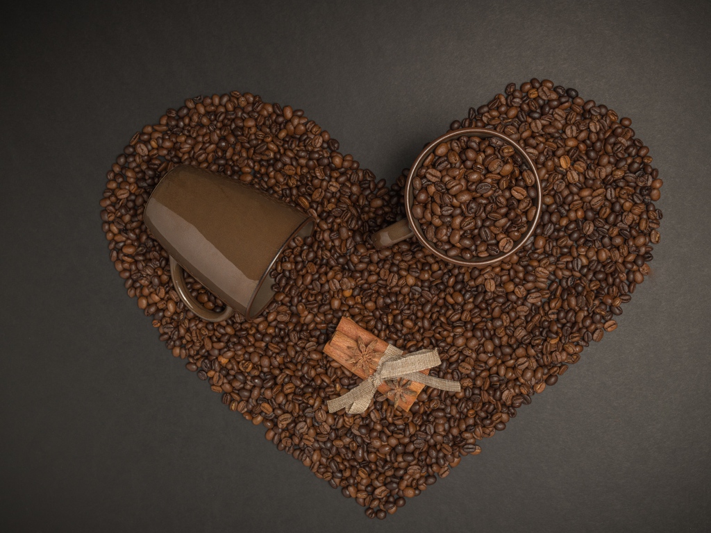 Сердце из кофейных зерен на сером фоне с кружками 