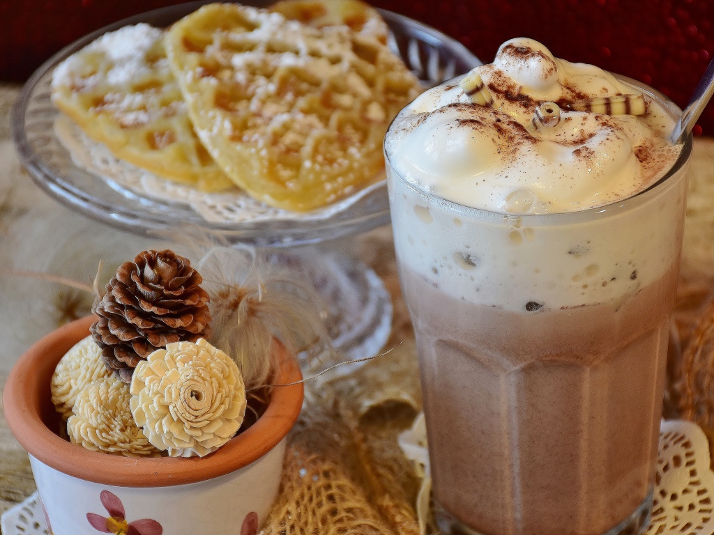 Горячий шоколад со сливками на столе с печеньем