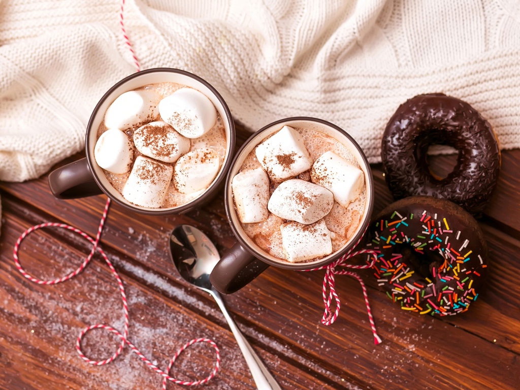 Горячий какао с маршмеллоу с пончиками на столе 