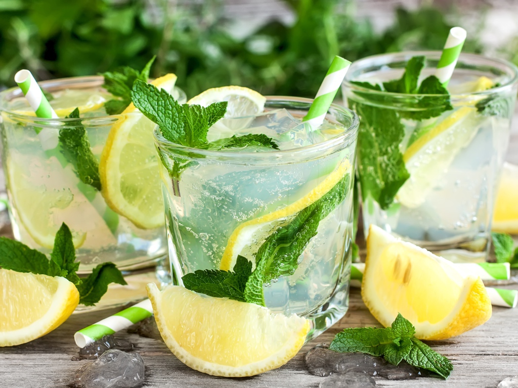 Лимонад с мятой и кусочками лимона в стаканах на столе