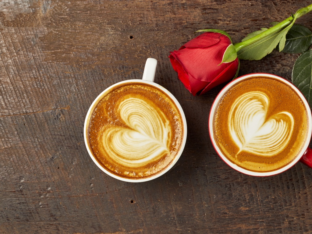 Две чашки капучино на столе с красной розой 