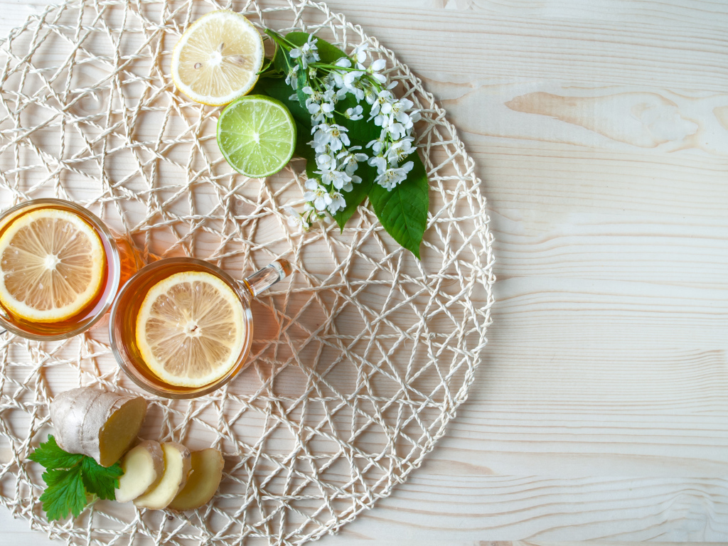 Две чашки чая с лимоном на плетеной подставке 